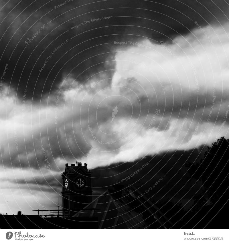 The hands of the church tower clock are no longer set to 12 - will the future be light, will it be dark?  - the sky has not yet decided. Clouds Town roofs huts