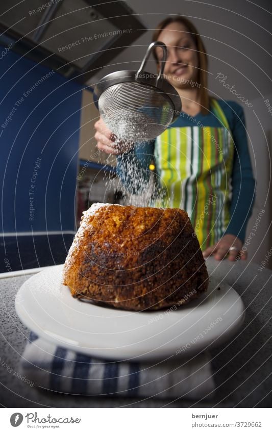 Woman with a bundt cake in a kitchen Gugelhupf Sweet Dessert Eating Sugar Delicious Cake background Nutrition feminine biscuits homemade sprinkle ready to eat