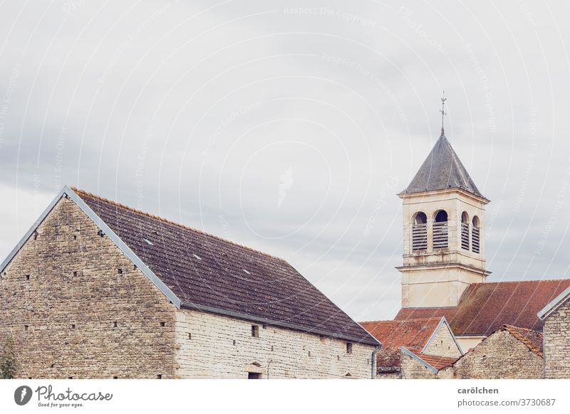 Village in the French countryside Church spire Roof roofs Wall (barrier) Covered Sky grey Dreary Simple unostentatious Calm Old town France