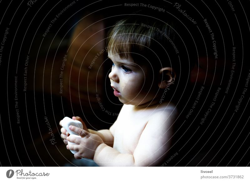 baby playing with stones in the dark kid child boy blue eyes tender people portrait lifestyle family one people one year europe spain cute nice handsome babe