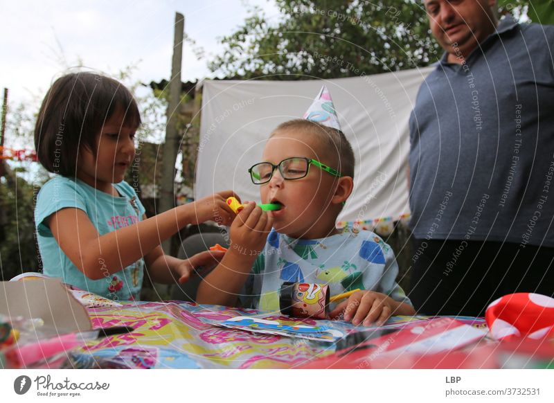 real life scene from a birthday party Paper Home-made years age Curiosity Laughter Birthday celebration Lifestyle Funny Garden smile Playing Emotions Parenting