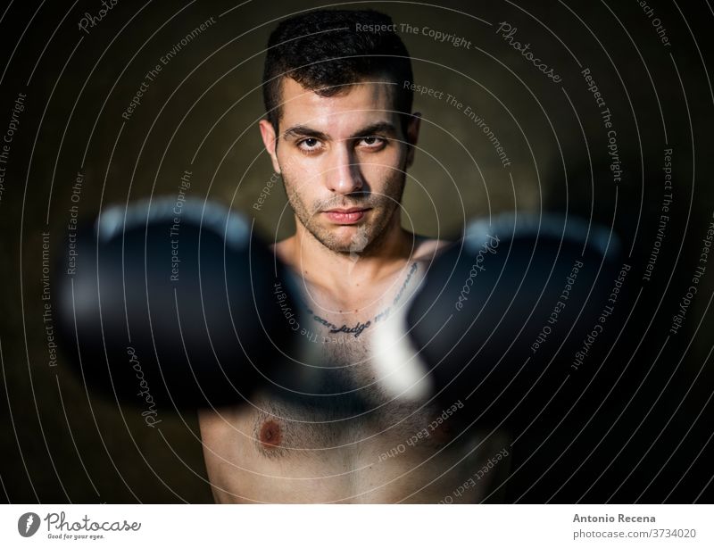 Muai thai fighter posing in studio shot with tattoos boxer sweat kick forearms violence power strong male competitive fitness 20s protection strength athlete