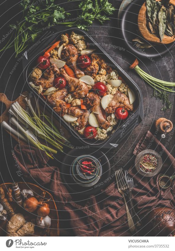 Fresh cooked food in baking dish with various ingredients. Kitchen equipment. Dark concrete background.Flat lay. Top view copy space kitchen cloth fresh forks