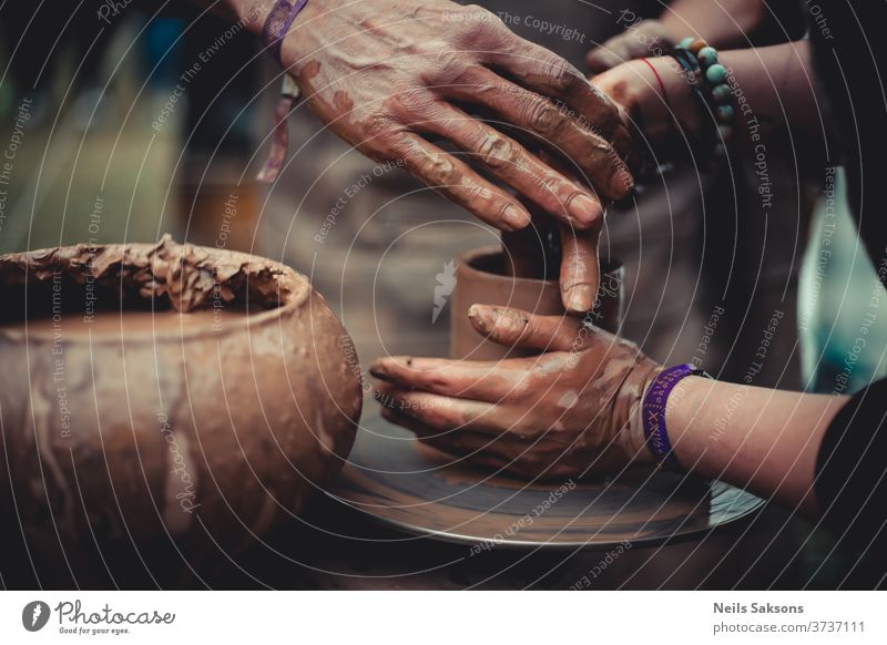 close up of hands of a potter and his student learning pottery clay wheel craft art ceramic work ceramics handicraft skill bowl making artist handmade finger