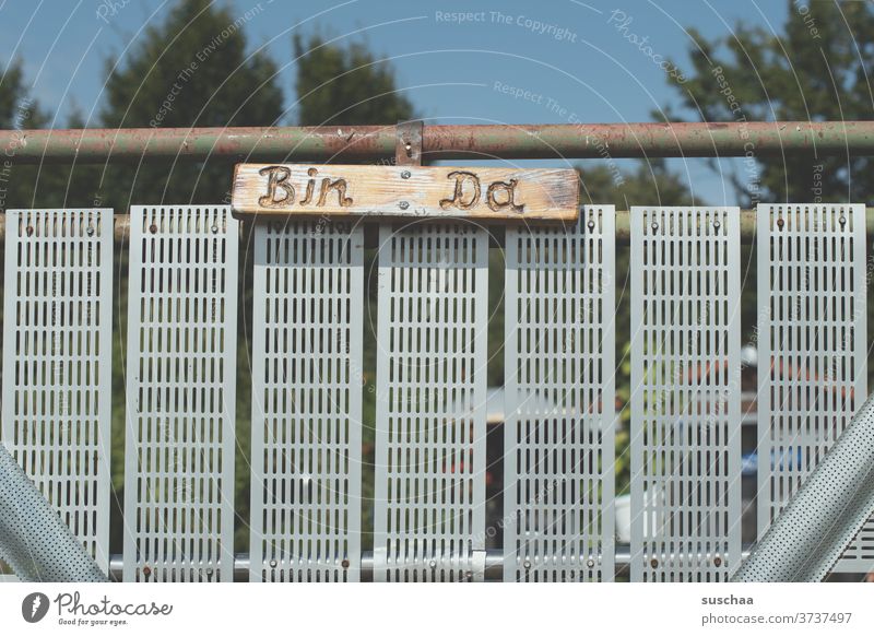 Garden gate marked "bin da" Garden door Goal Communication Iron gate iron rod Metal metal grid Inscription Letters (alphabet) words I'm here. Clue Entrance