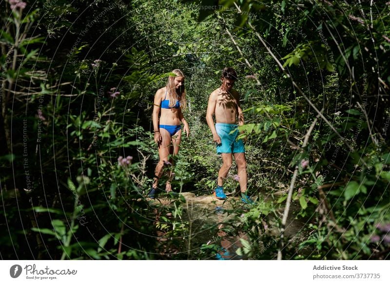 Traveling couple near lake in forest travel relax together swimwear holiday summer pond nature serene vacation journey sunlight woods water relationship trip