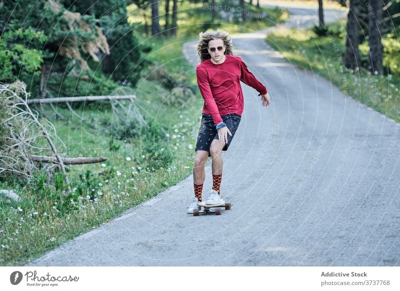 Young man riding skateboard in park ride hipster road summer trendy fancy skater male style hobby modern active activity handsome motion freedom enjoy guy focus