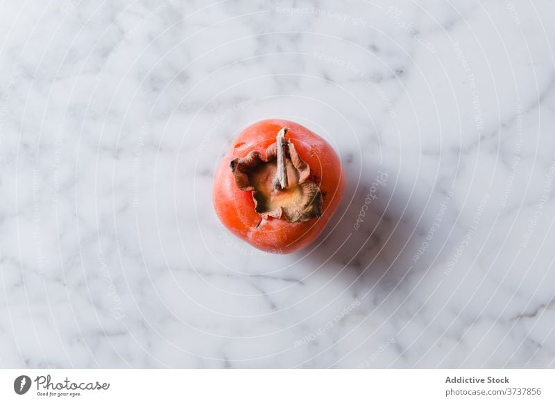 Fresh persimmon on table in kitchen fruit vitamin ripe fresh healthy food sweet nutrition fiber diet nutrient delicious bright natural organic home meal tasty