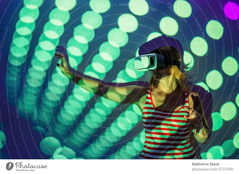 Woman in VR goggles exploring virtual reality woman vr headset touch experience explore illuminate projector technology innovation gadget entertain digital