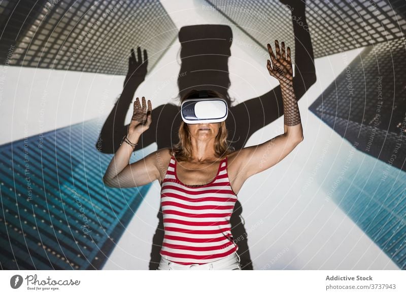 Excited woman in VR headset exploring virtual city vr virtual reality skyscraper building urban goggles touch excited experience effect explore technology