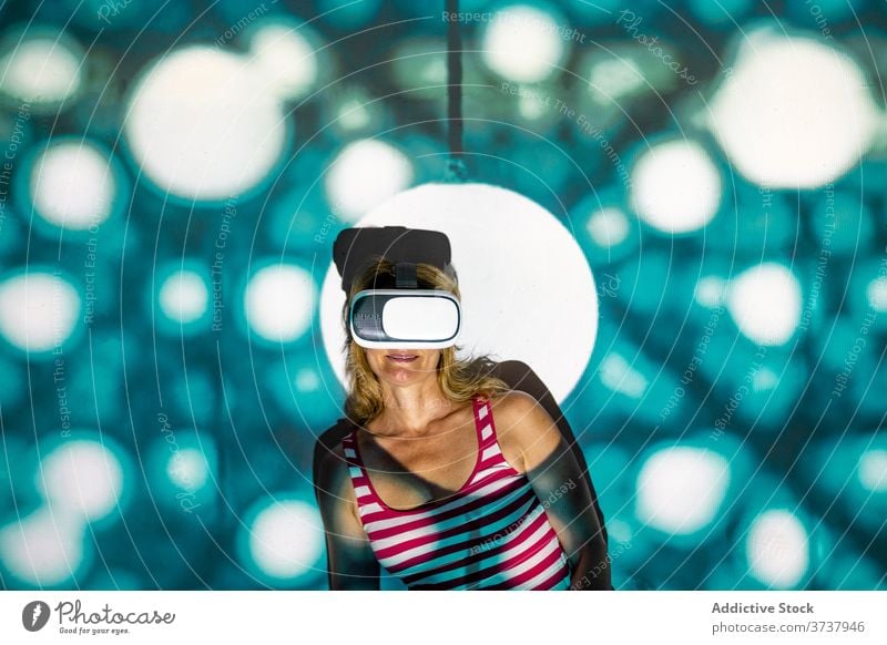 Woman in VR goggles exploring virtual reality woman vr headset touch experience explore illuminate projector technology innovation gadget entertain digital