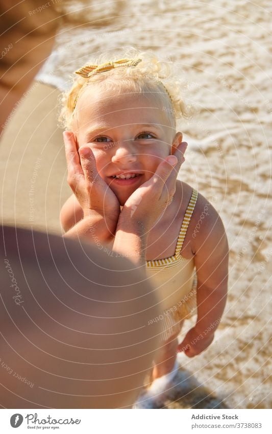 Selective focus on the face of a blonde girl with a happy expression on the beach embrace tan share talk togetherness bonding brother harmony stand learning