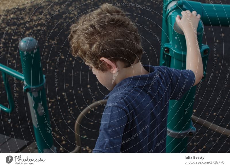 Boy on school playground School Playing Child Boy (child) Elementary school elementary Blue Green Curly Curly hair solitude alone pupil jungle gym park Recess