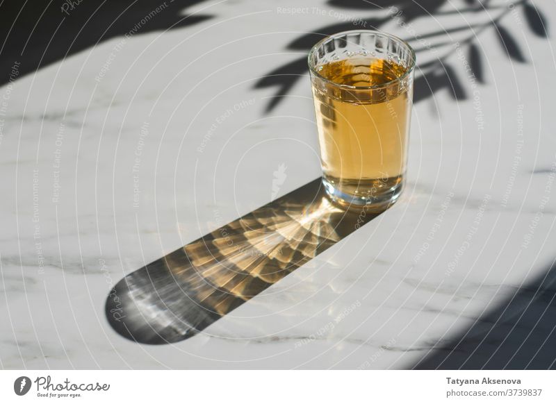 Glass of herbal or green tea at marble table glass hot healthy drink autumn natural beverage flower white medicine refreshment plant closeup alternative