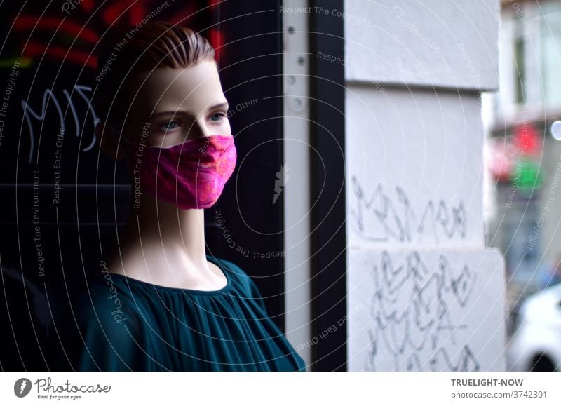 corona thoughts | Pale, lifeless model in a dark green velvet blouse with smooth back-combed hair and a red mouth-nose cover stands in a gate entrance at Hackescher Markt in Berlin-Mitte