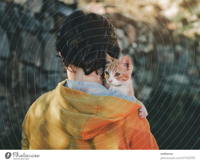 Back view of child with kitten kid pet cat pets love domestic stray homeless adorable people toddler baby lost outdoor small alone urban curiosity little street