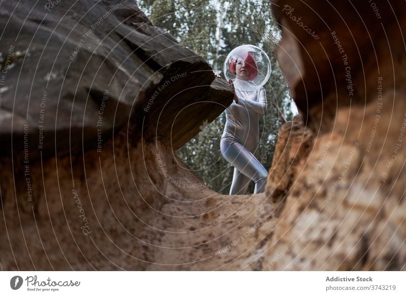 Smiling futuristic woman in sliver suit space astronaut positive young rock stone cosmonaut costume concept female silver helmet smile confident happy cheerful