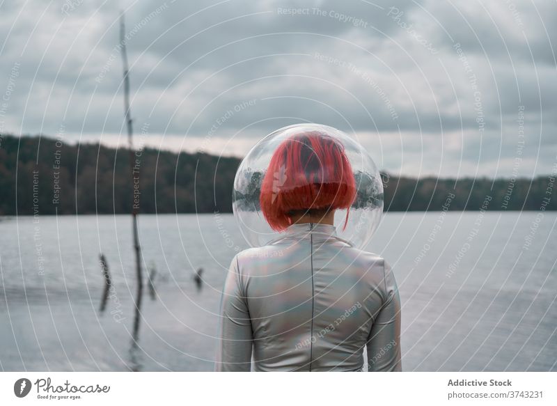 Woman in astronautic suit walking on water woman futuristic space helmet river nature cosmonaut concept female silver future fantasy science explore planet