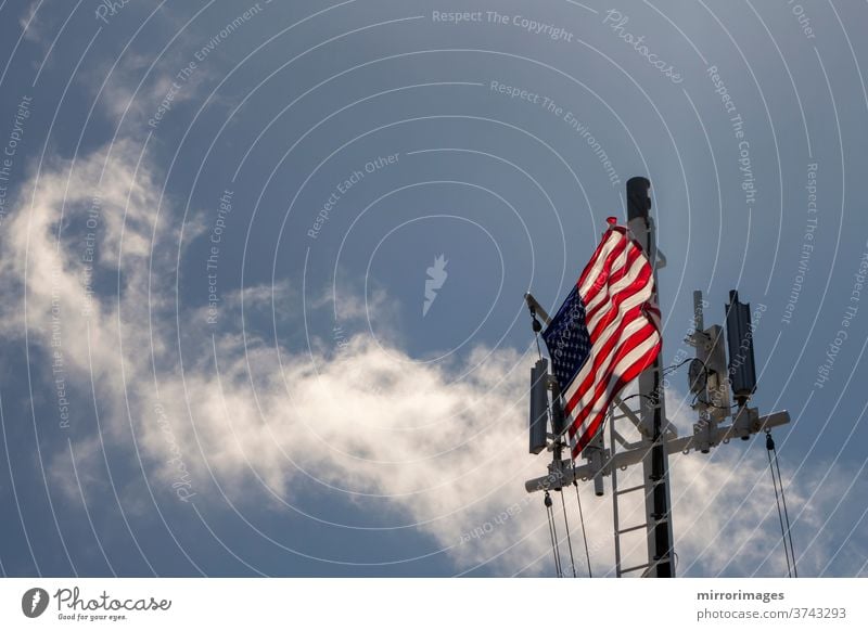 United States of America Flag Blowing in the Wind on the deck of a large ship at sea with cell towers america american banner battleship blue boat breeze