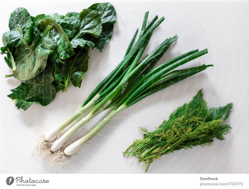 Fresh garden herbs over marble table. Green: green onions, dill and spinach color summer top view flat lay veggies grass vegan flavor vitamin eat greens above