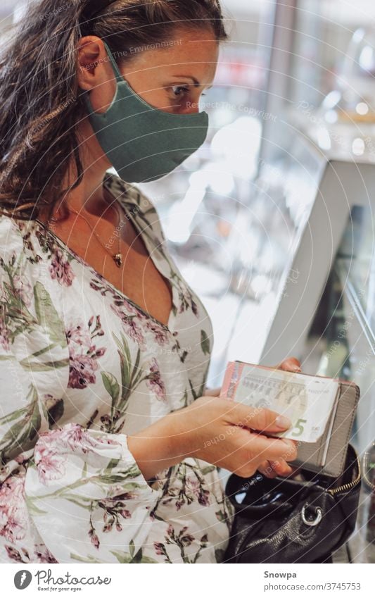 Young woman buying products with face mask on. Shopping during pandemic. Travel during pandemic. Personal safety. safe travel travel during pandemic fashion