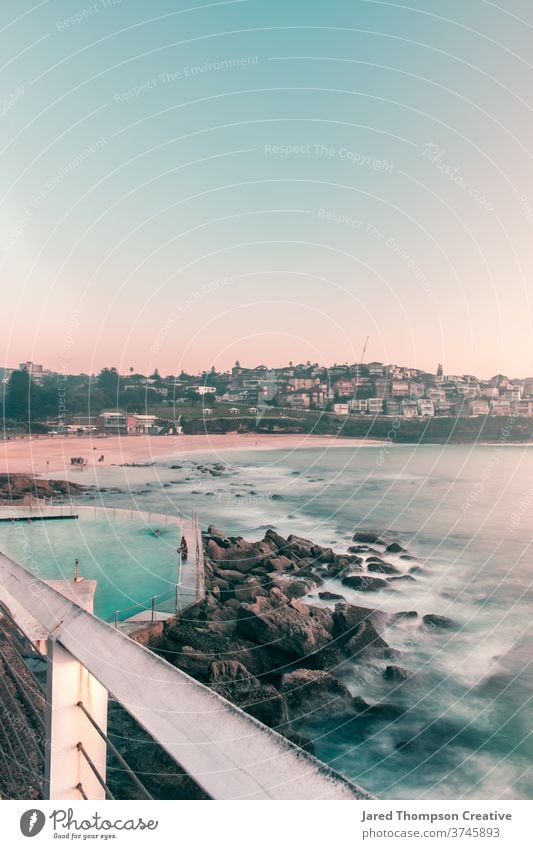 A pink spring sunrise overlooking Bronte Baths in Sydney, Australia. bronte baths ocean pool pools australia nsw newsouthwales eastcoast beach rocks summer