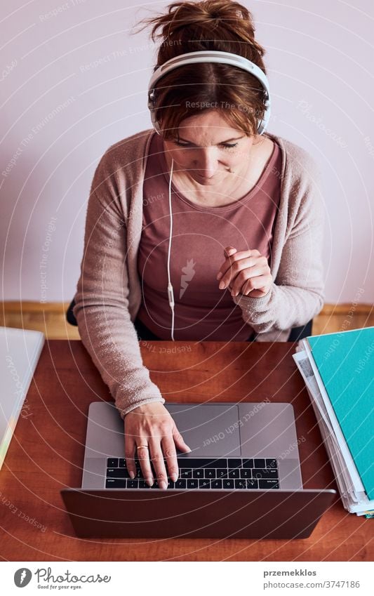 Woman working talking doing her job remotely during video chat phone call on laptop from home binder class classes computer connect connecting copy space