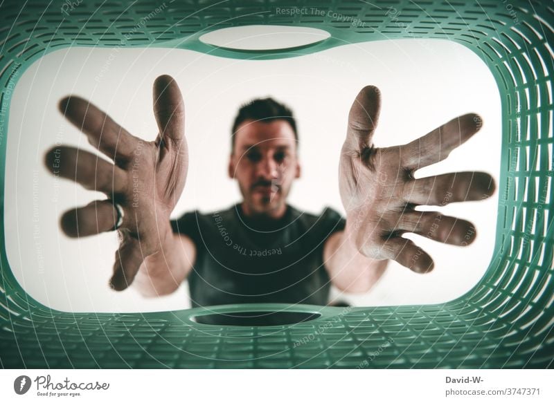 Man reaches into a laundry basket Househusband Household Laundry basket Washing Tidy up Housekeeping Washing day Exasperated Sour hands Grasp