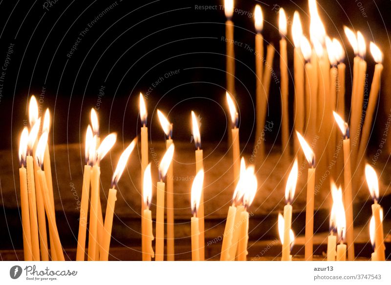 Group of yellow candles in church for faith resurrection prayer. Candlelight fire flames in circle rows are religion symbol for peace, life and soul silence. Obituary hope sacrifice against sorrows