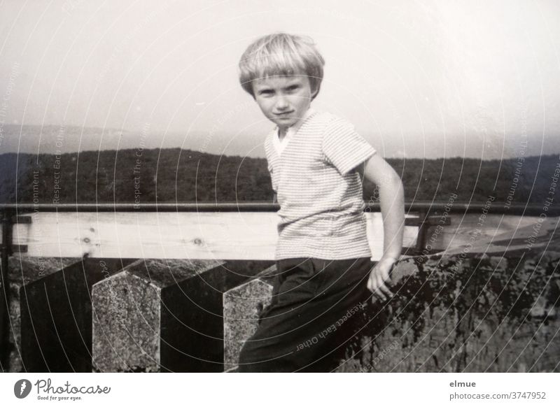 Memories of the 1970s - a black and white photo print shows a girl with a bubble-head hairdo and casual casual clothes standing on a tower paper image then