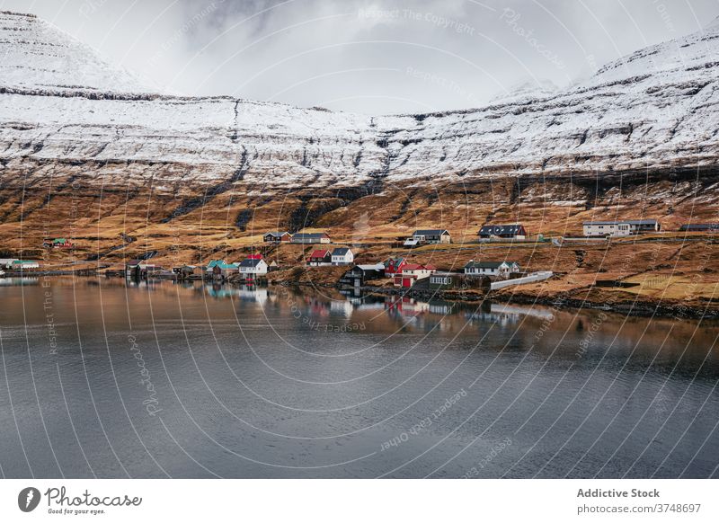 Small settlement in mountains on Faroe Islands village winter snow river season cold house residential faroe islands scenery breathtaking scenic countryside