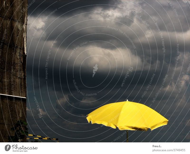 The bright yellow parasol still stole the show from the dark thunderclouds. Summer Rain Town Bad weather Clouds Sky Weather sunshine Flak tower barrier tape