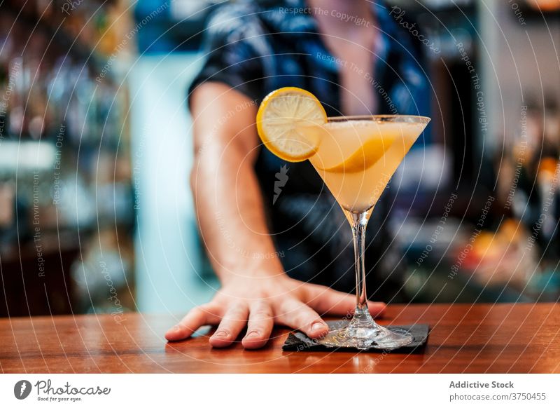 Bartender pouring cocktail in glass at counter alcohol prepare bartender man barman refreshment drink beverage goblet liquid serious professional booze cold mix