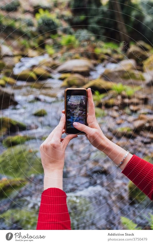 Traveling woman taking photo on smartphone in forest take photo traveler enjoy river woods memory nature female valle del jerte caceres spain tourist shore sit