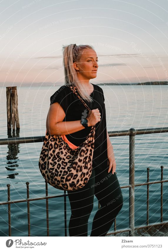 Young woman on the shore of Lake Constance Bavaria badenwürtenberg Vacation mood Dusk Sunset Vacation & Travel Summer Blue Water Lakeside tranquillity