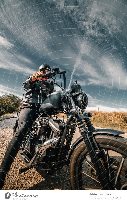 Brutal biker sitting on motorcycle in countryside motorbike ride drive man road power rider brutal speed fast travel freedom transport adventure vehicle journey