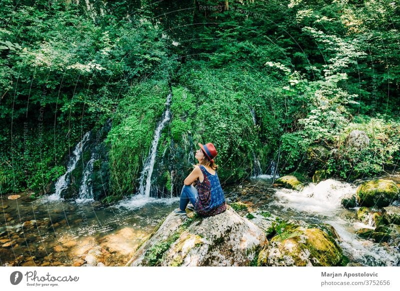 Young female nature explorer enjoying by the waterfalls adventure beautiful cascade casual caucasian discover discovery flow flowing forest fresh girl green