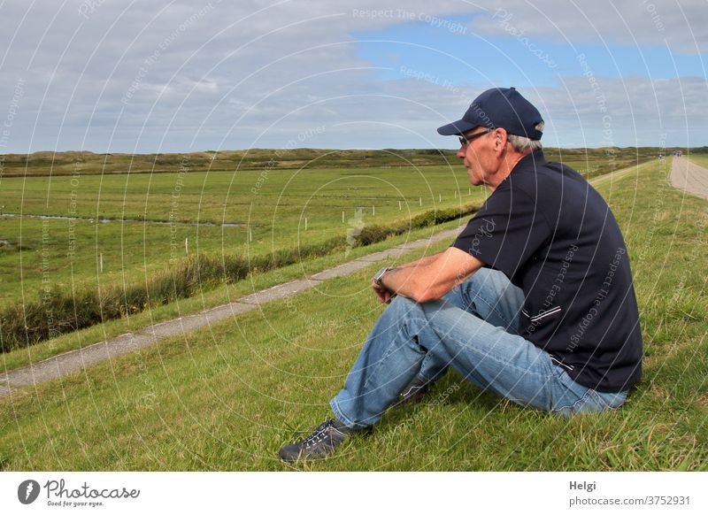 Break - male senior sits at the dike and looks at the meadows Human being Man Senior citizen age 60 years and older Male senior 1 portrait Adults Exterior shot