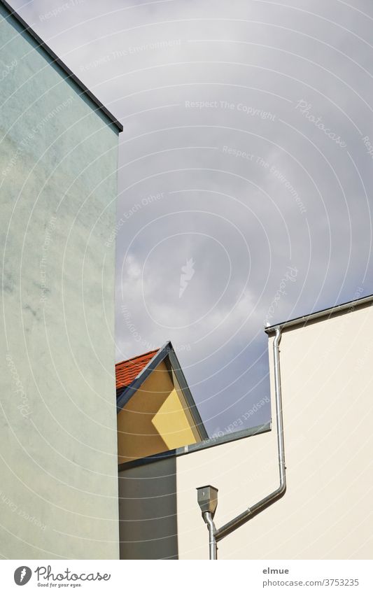 Mix of shapes and lines of differently coloured house walls with gutter and downpipe against a cloudy sky, casting shadows House (Residential Structure) Colour