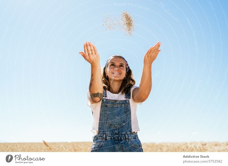 Cheerful woman with wheat grain in field countryside village agriculture toss cheerful cereal female summer meadow idyllic season cultivate sunny plant happy