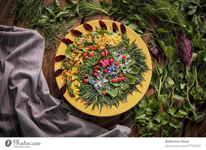 Delicious greenery with flower petals on plate composition herb arrangement wooden table ripe fresh nature summer bloom flora healthy season floral plant