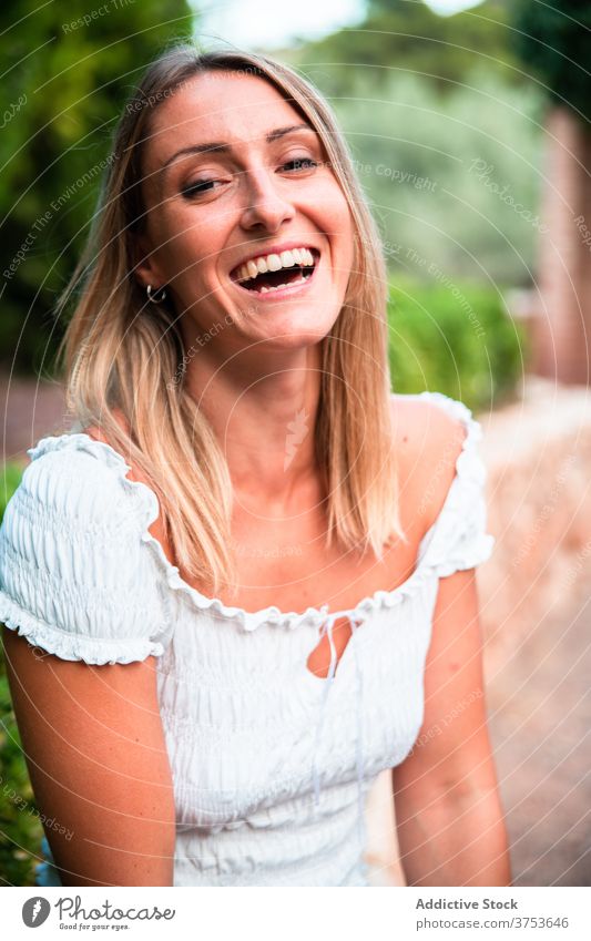 Smiling woman in park in summer charming relax garden smile enjoy weekend rest female border green stone sit chill calm tranquil cheerful lady serene idyllic