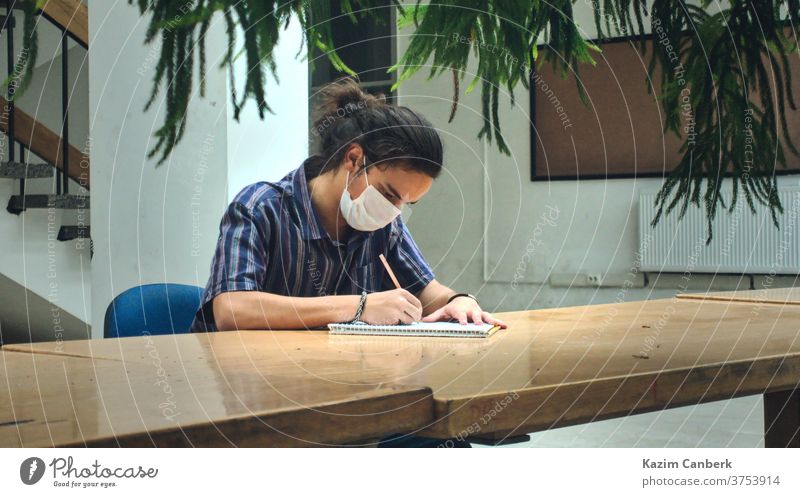 Isolated masked college student studying alone in the library with beauitful sunlight corona background white isolated health science medical art healthy virus