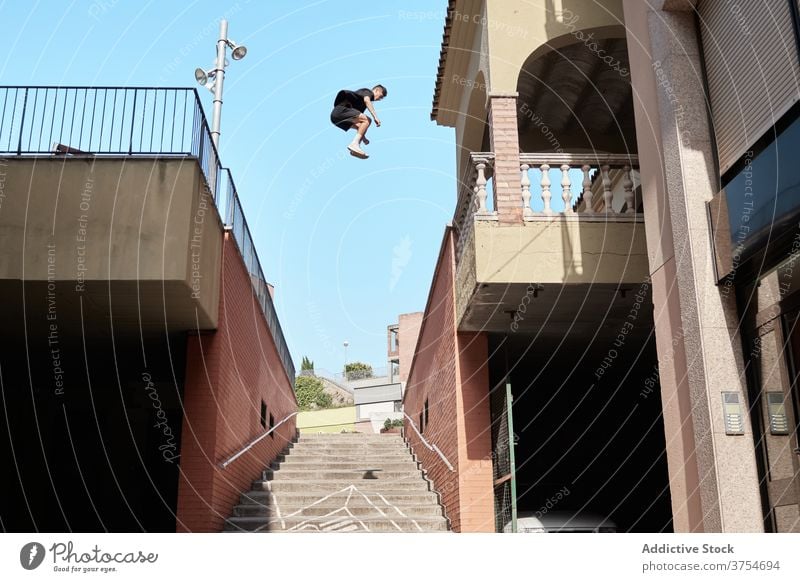 Man jumping over stairway in city parkour stunt trick man urban extreme danger hobby courage active activity professional brave adrenalin cool energy skill