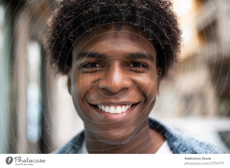 Delighted ethnic man looking at camera delight portrait smile handsome charismatic city afro hairstyle appearance male black african american street positive