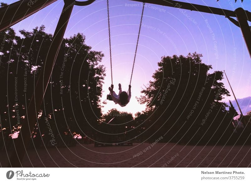 Little Girl in the park playing on the swing. View of a beautiful sky. children blue heaven future innocence beauty physics hope look complicity happy childhood