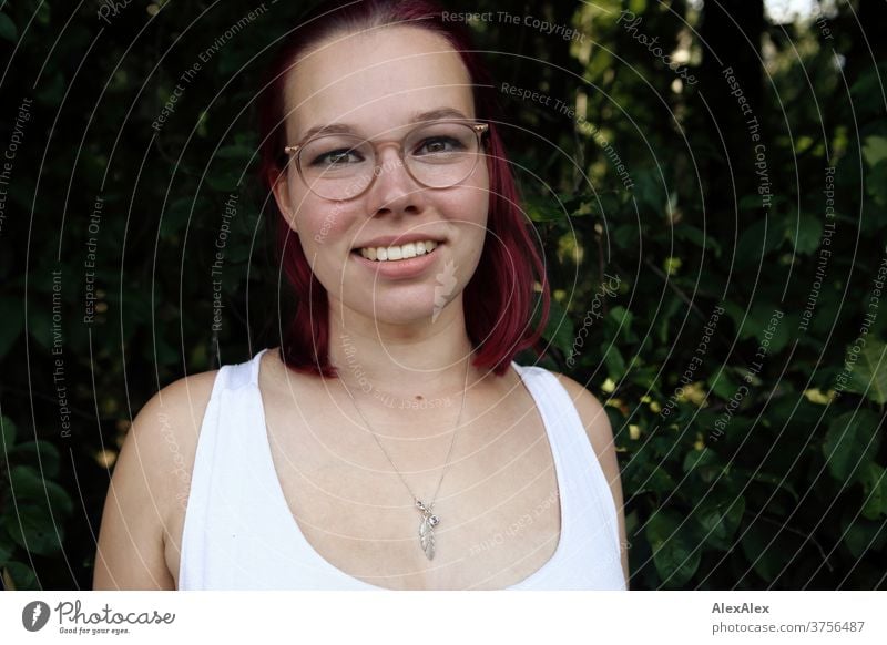 Portrait of a young, smiling woman in a white undershirt in front of a bush Woman Young woman girl already daintily Athletic Sunlight Summer Desirable Adults