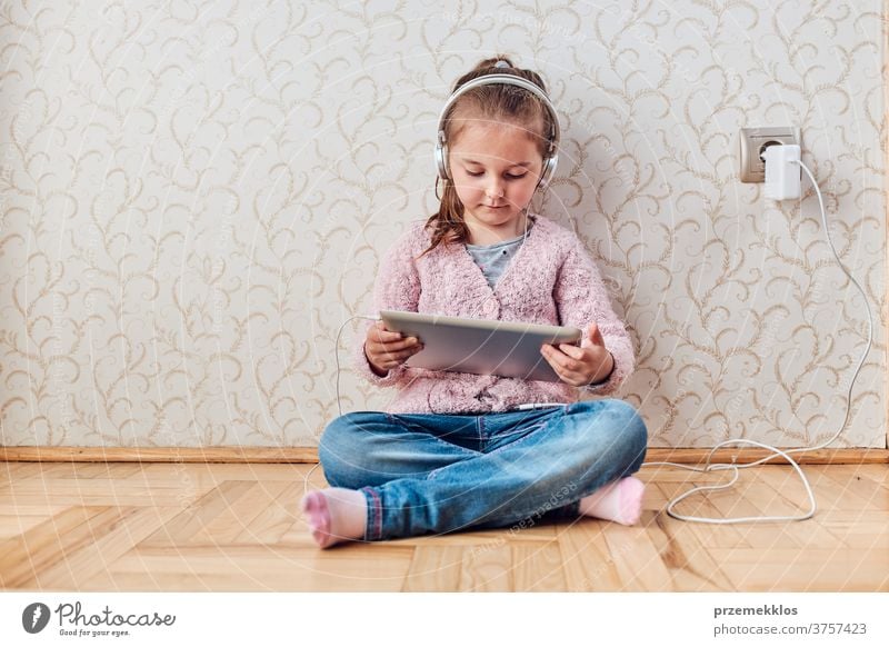 Little girl preschooler learning online solving puzzles playing educational games on tablet at home attention bed bedroom caucasian child childhood computer