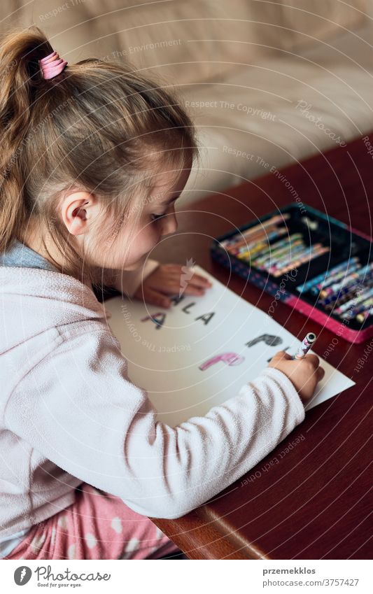 Little girl preschooler learning to write letters at home attention caucasian child childhood cute education educational fun kid little looking one person room