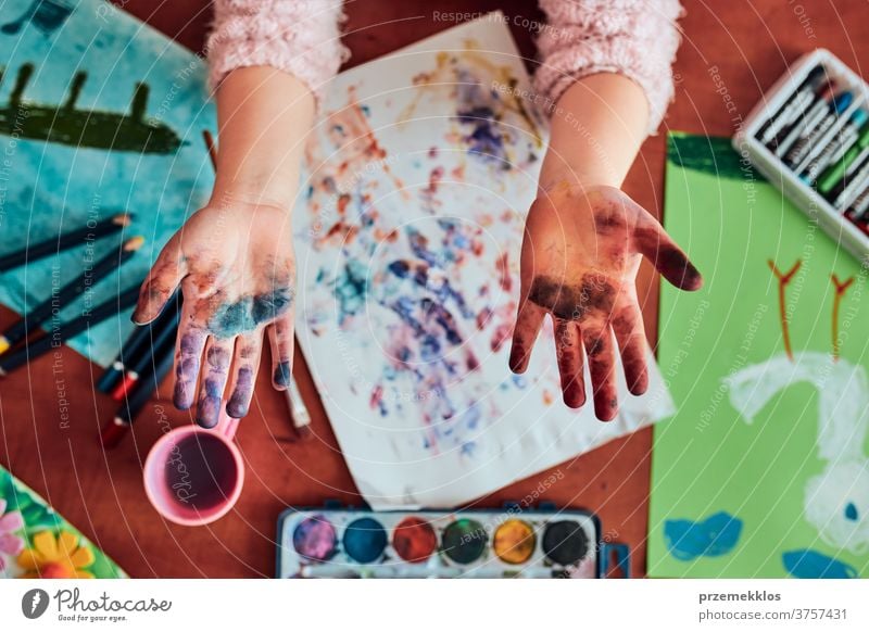 Little girl preschooler showing painted colourful hands child painting dye education colorful art home paper childhood creation craft table creativity kid